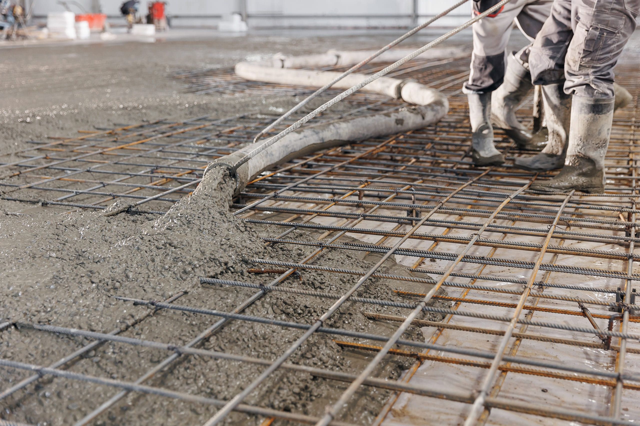 Beton wird über eine Bewehrungsmatte gepumpt und verteilt